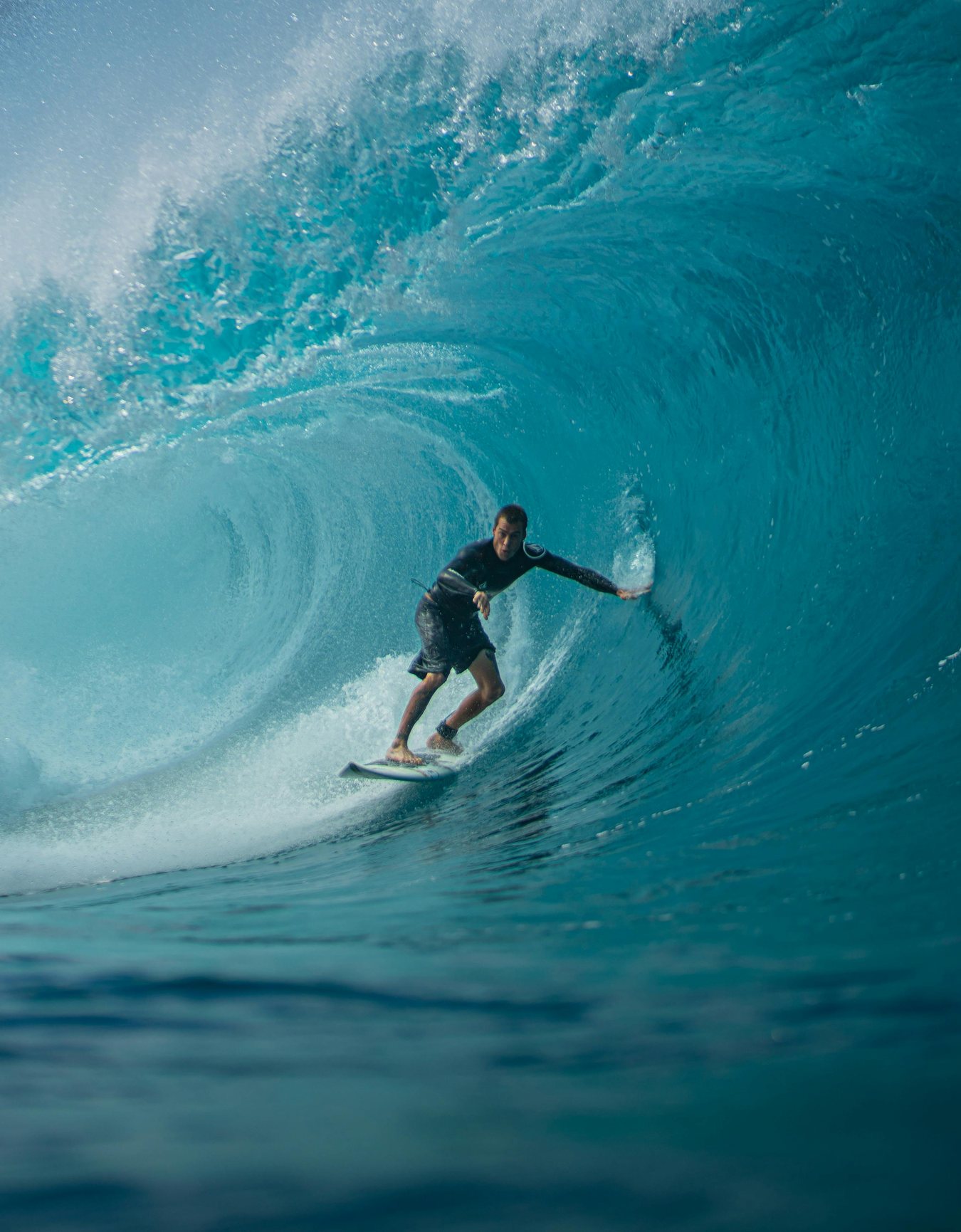 Un surfista avanza dentro de una ola que se cierra sobre él.
